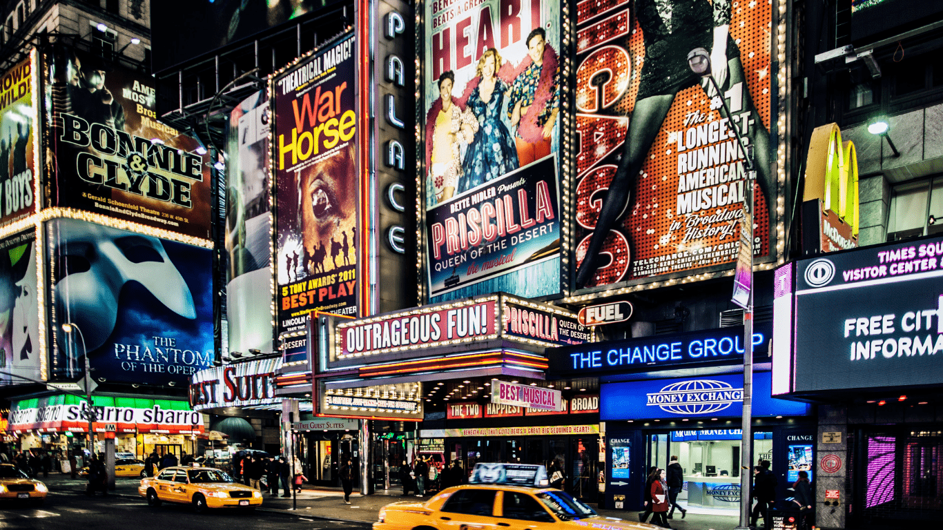A bustling city street filled with colorful billboards and yellow taxis navigating through traffic