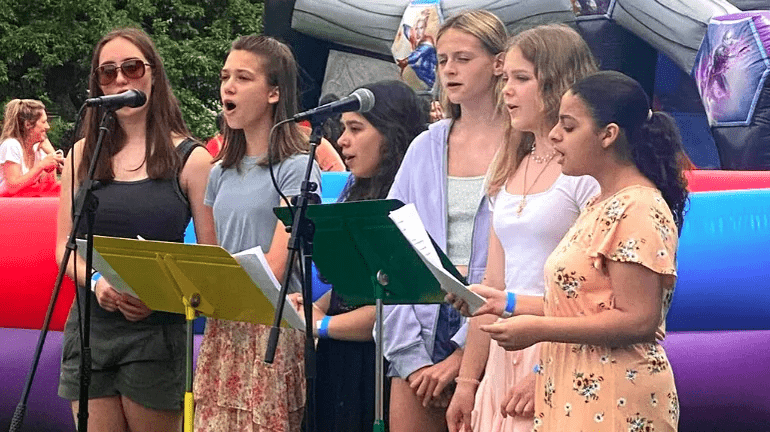 A group of people gathered around a microphone, singing together in a lively and engaging atmosphere